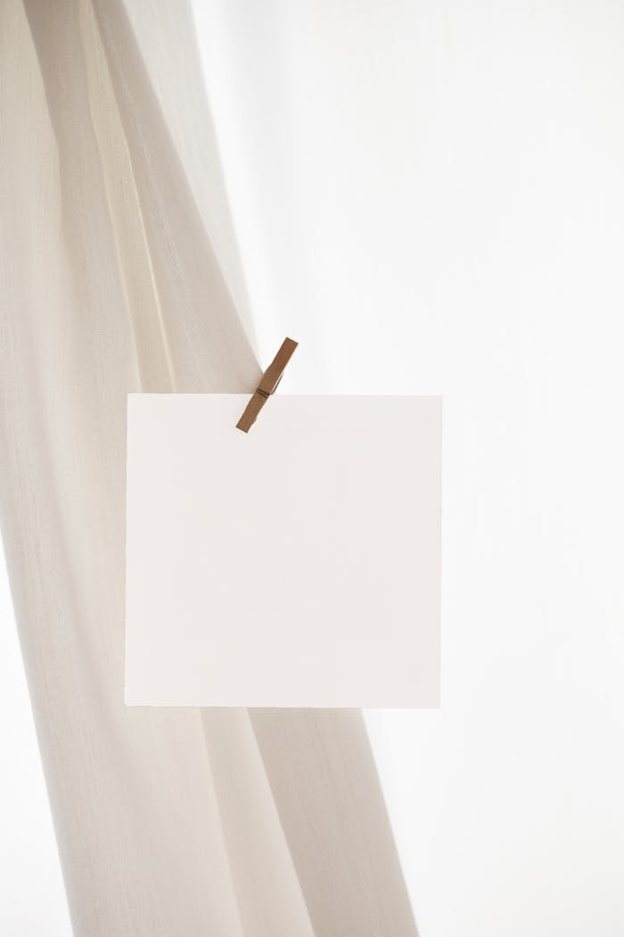 Simple blank card clipped to fabric, ideal for mockup designs with ample copy space.